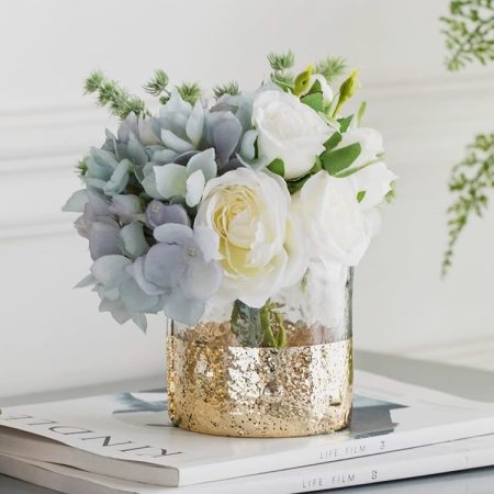 Artificial flower arrangement in a gold-dipped glass vase.